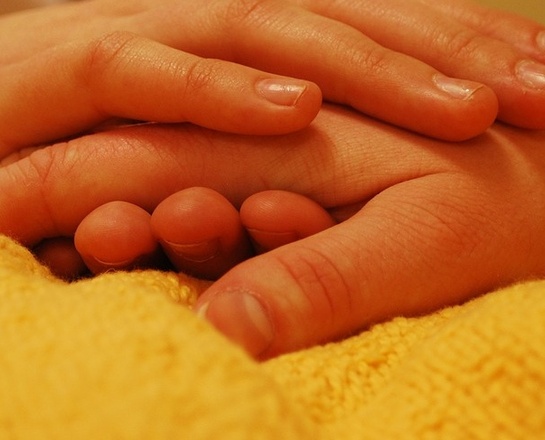 Hände Eine Pflegerin greift die Hand eines Kranken.