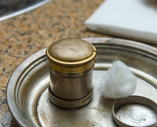 Taufe Am Rand eines Taufbeckens stehen Chrisamöl und eine Muschel für das Taufwasser.